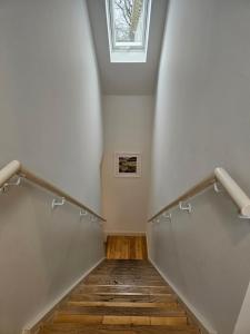 a hallway with stairs with a skylight and a window at The Wee Corsee Cosy Coastal Cottage in the Heart of Nairn in Nairn