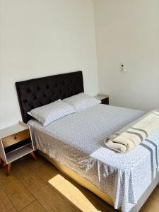 a bedroom with a bed with a black headboard at Apto Rio grande com varanda e 160mt de terraço in Rio Grande