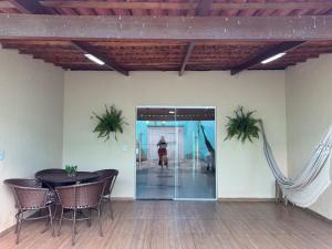 a room with a table and chairs and a person in the background at Casa Mobiliada AR02 com 3 camas e 2 quartos in Juazeiro do Norte
