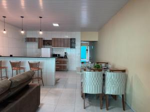 a kitchen and living room with a couch and a table at Casa Mobiliada AR02 com 3 camas e 2 quartos in Juazeiro do Norte