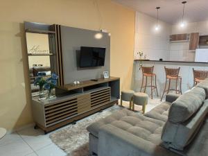 a living room with a couch and a kitchen at Casa Mobiliada AR02 com 3 camas e 2 quartos in Juazeiro do Norte