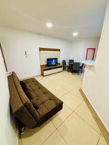 a living room with a brown couch in a room at Apto Rio grande com varanda e 160mt de terraço in Rio Grande
