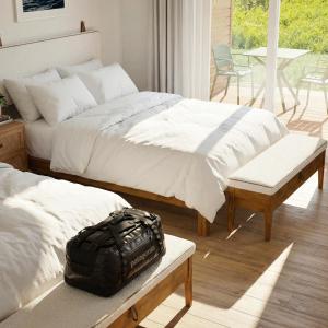 a bedroom with two beds and a bag on a bench at Motel Seal Rock in Perce