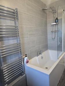 a bathroom with a white tub and a shower at Grace's Spacious Home in Ely in Ely +28 photos