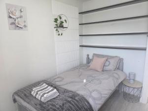 a white bedroom with a bed with two pillows on it at Grace's Spacious Home in Ely in Ely