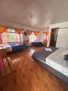 a large bedroom with two beds and windows at Hotel Minnesota y Centro de Eventos Molina in San Lucas Tolimán