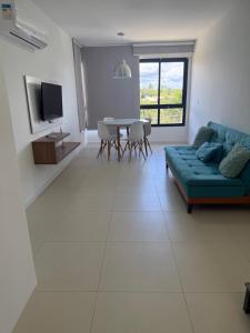 a living room with a blue couch and a table at Paraiso dos coqueiros - Guarajuba - Bahia -Linha verde in Camaçari