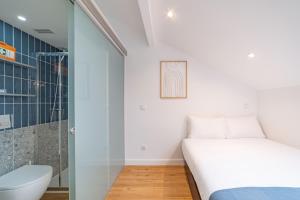 a small bedroom with a bed and a shower at Hygge Smart Stays in Lisbon +85 photos