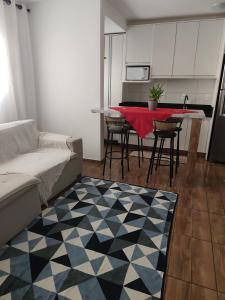 a living room with a couch and a table with chairs at Apt confortável in Camboriú