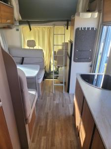 eine Innenansicht eines Wohnmobils mit Tisch und Stühlen in der Unterkunft Signature Camper in Rédange