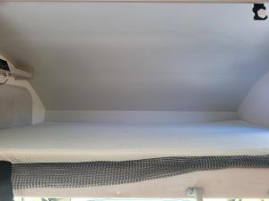 ein kleines Bett in einem kleinen Zimmer in der Unterkunft Signature Camper in Rédange