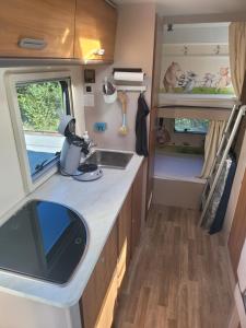 Eine Küche in einem Wohnmobil mit Spüle in der Unterkunft Signature Camper in Rédange