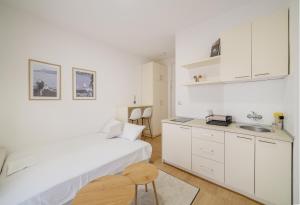 a white bedroom with a bed and a sink at Sea Point Apartments Igalo in Igalo