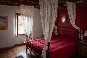 a bedroom with a red bed and a window at Le Ortensie Lago di Garda in Monzambano