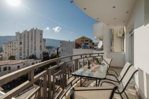 a balcony with a table and chairs on a balcony at Sea Point Apartments Igalo in Igalo
