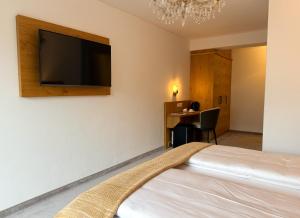 a bedroom with a bed and a flat screen tv on the wall at Thurners Boutique Hotel at Großglockner, Film Inspired in Bruck an der Großglocknerstraße