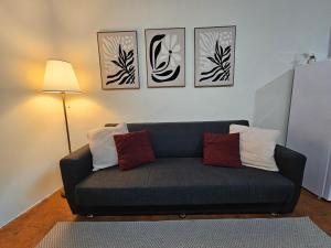 a couch in a living room with four pictures on the wall at Appartamento La Locanda Del Castello in San Panfilo dʼOcre