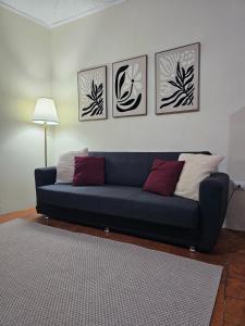 a blue couch in a living room with four pictures on the wall at Appartamento La Locanda Del Castello in San Panfilo dʼOcre