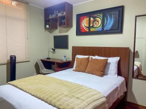 a bedroom with a bed and a desk in it at High Garden Apartment in Trujillo