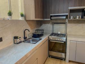 a kitchen with a sink and a stove at High Garden Apartment in Trujillo