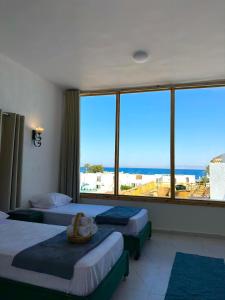 a hotel room with two beds and a large window at Classic Home DaHaB in Dahab +96 photos