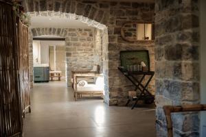 a room with a stone wall and a room with a table at Couvent de la Salette & Spa in Millau