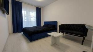a living room with a couch and a chair at 85th Pool View Studio in Popeşti-Leordeni