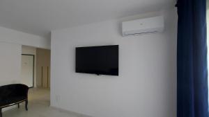 a living room with a tv on a wall at 85th Pool View Studio in Popeşti-Leordeni