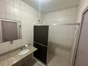 a bathroom with a shower and a sink and a mirror at Hotel Guaporé - Campo Bom RS in Campo Bom +72 photos