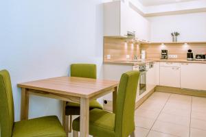 ペットイ・アム・アールベルクにあるApart Mirjamのキッチン(木製テーブル、緑の椅子付)