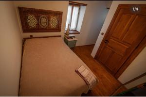 a small bedroom with a bed and a wooden door at Flora Birgi Taş Konak in Odemis