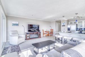 a living room with a couch and a kitchen at Fun Times At Nye Beach in Newport