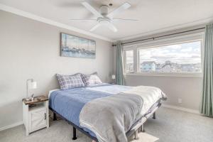 a bedroom with a bed with a ceiling fan and a window at Fun Times At Nye Beach in Newport