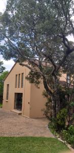 a house with a large tree in front of it at Selah Sands in Port Alfred