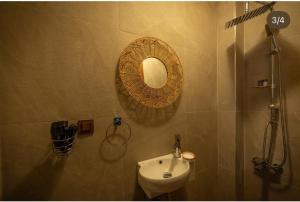 a bathroom with a sink and a mirror on the wall at Flora Birgi Taş Konak in Odemis
