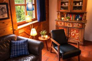 a living room with a leather couch and a chair at Gibbesbachhof Black Forest Apartments in Triberg
