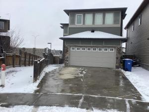 a house with a garage in the snow at Comfortable Stay Evanston NW - Near YYC Airport, Highways, Shopping & Parks in Calgary