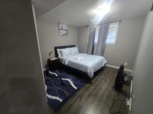 a bedroom with a bed and a blue rug at Comfortable Stay Evanston NW - Near YYC Airport, Highways, Shopping & Parks in Calgary