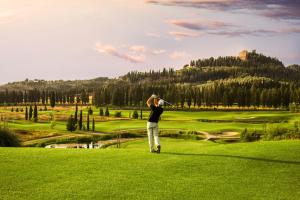 Un uomo sta giocando a golf su un campo da golf di Hotel Miravalle a San Miniato