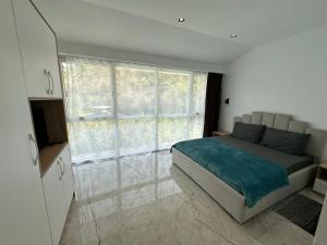 a bedroom with a bed and a large window at guest house Qyteza in Shkodër