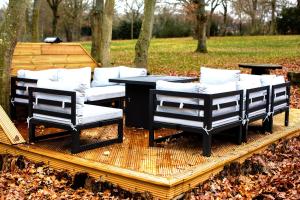 two chairs and a table on a wooden deck at Countryside Cabin on 5 Acres Countryside with Outdoor Firepit, Cinema and converted Stables in Sible Hedingham