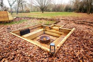 a backyard garden with a fire pit in the ground at Countryside Cabin on 5 Acres Countryside with Outdoor Firepit, Cinema and converted Stables in Sible Hedingham