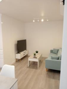 a living room with a couch and a tv at Apartamentos Antuña in Cangas de Onís