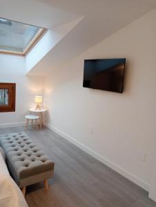 a room with a bed and a tv on the wall at Apartamentos Antuña in Cangas de Onís