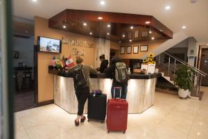 two people with luggage standing at a counter in a store at Royal Inn Cusco Hotel in Cusco +90 photos