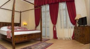 a bedroom with a canopy bed with red curtains at Hotel Regal 1880 - Boutique Hotel in Parcul Central Sinaia in Sinaia +70 photos