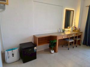 a desk in a room with a table and a mirror at the stay bangsaen in Ban Rong Khoei