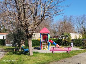 a park with a playground with a slide at Mobil home au bord du lac de Foix in Foix