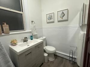 a white bathroom with a toilet and a sink at El Edén 2 Bedroom with parking Space close to hospital in Parkchester +10 photos