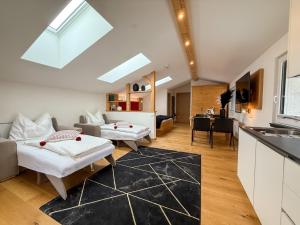a living room with two beds and a kitchen at Thurners Boutique Hotel at Großglockner, Film Inspired in Bruck an der Großglocknerstraße